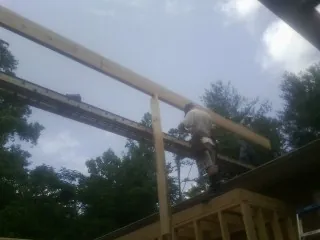 Carpenter setting a ridge beam over a new addition frame — Ice Dam Removal by Roofing Brothers in Buckeye Lake