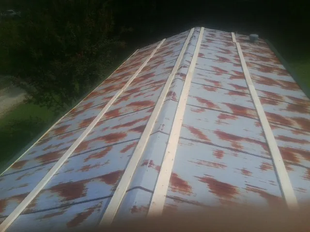 Rusted metal roof panels with new wood purlins before replacement — Storm Damage Roof Repair in Buckeye Lake by Roofing Brothers