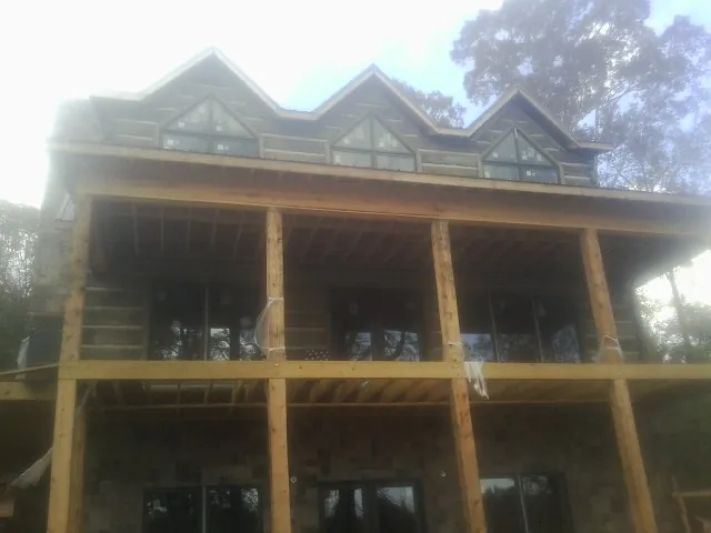 Dormers and porch framing on a large log home under construction — Roof Coating work by our crew in Buckeye Lake