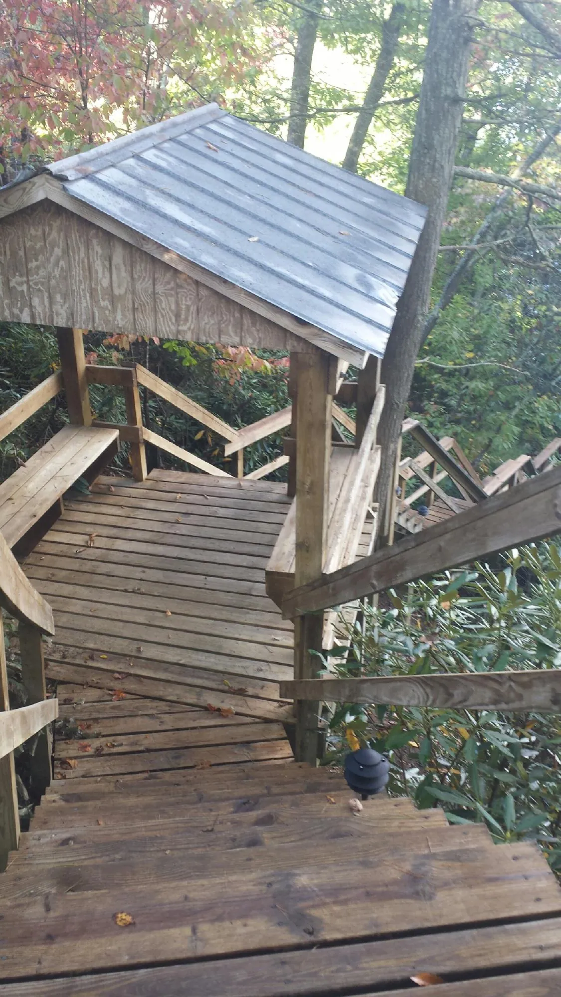 Metal roofed shelter over wooden steps on a wooded walkway — Skylight Repair & Installation work by our crew in Buckeye Lake