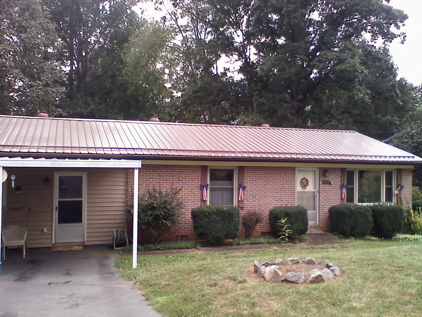 Bronze metal roof and carport on a brick ranch home — Roof Repair work by our crew in Buckeye Lake
